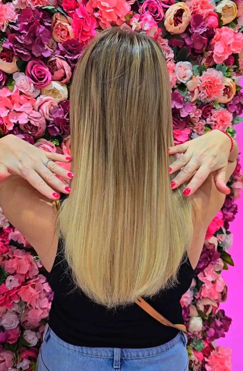 Smooth blow-dried hair photographed against a floral wall
