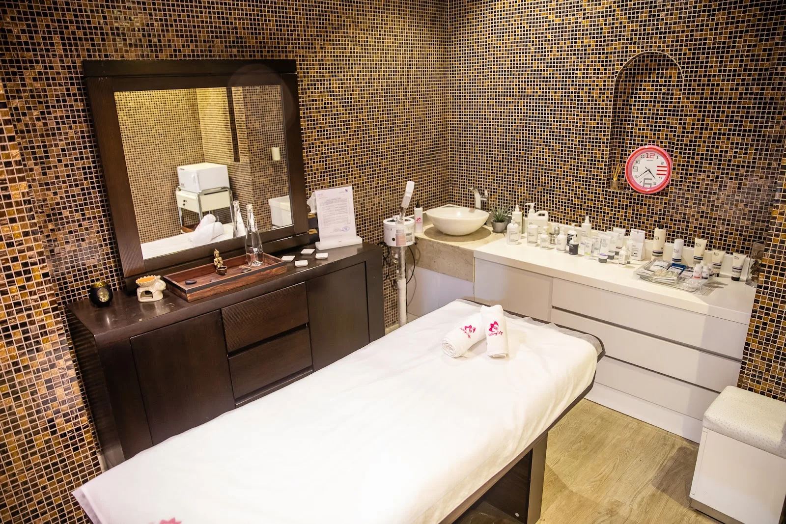Private treatment room with mosaic tiling and a massage bed