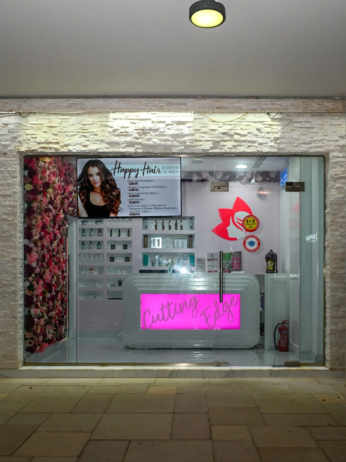 Cutting Edge salon storefront and reception desk in the evening