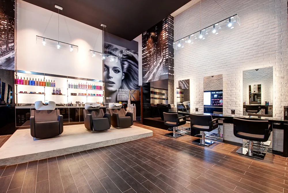 The Loft Fifth Avenue interior — hair-wash lounge with brick walls, skyline murals and dark wood floors