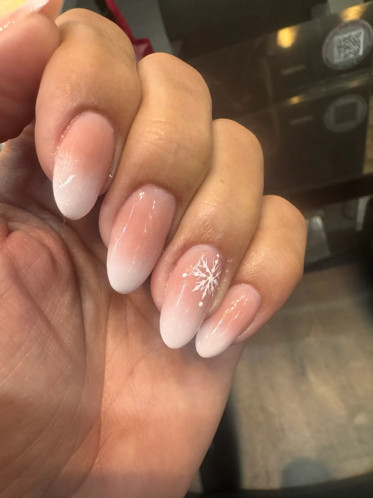 Soft ombré almond manicure with a delicate snowflake accent