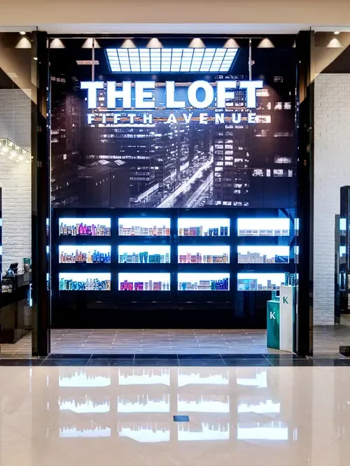 The Loft Fifth Avenue entrance with night-skyline mural and illuminated signage