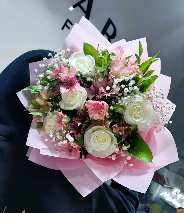A bouquet held up against the lit Dubai skyline at night