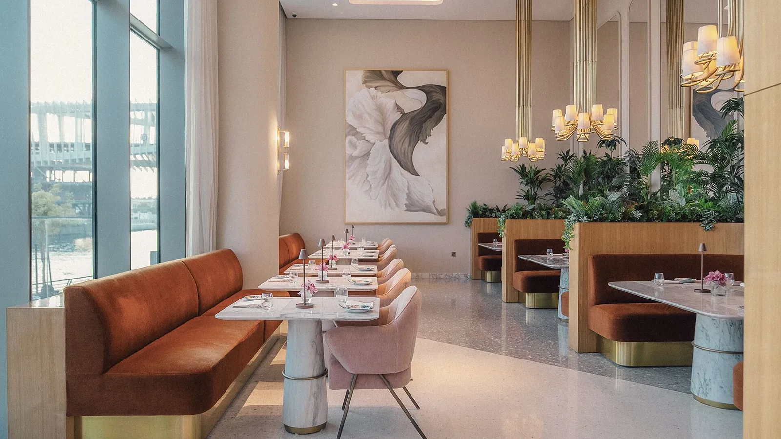 Row of blush dining chairs along floor-to-ceiling sheer curtains