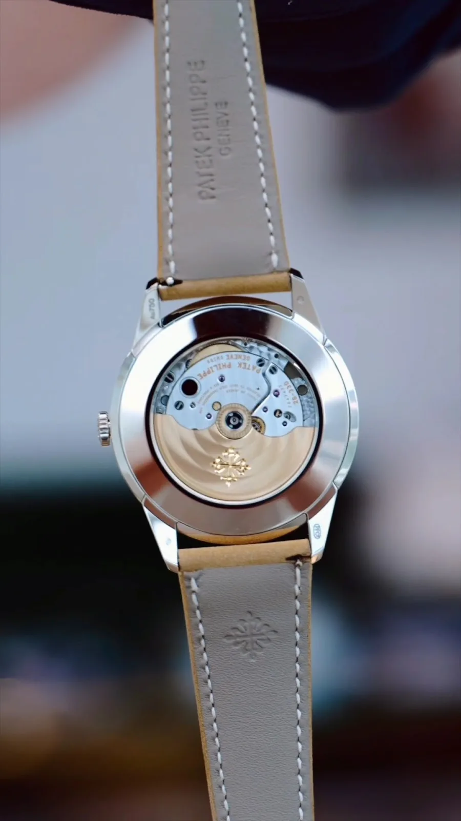 The exhibition caseback of a Patek Philippe automatic watch on a leather strap