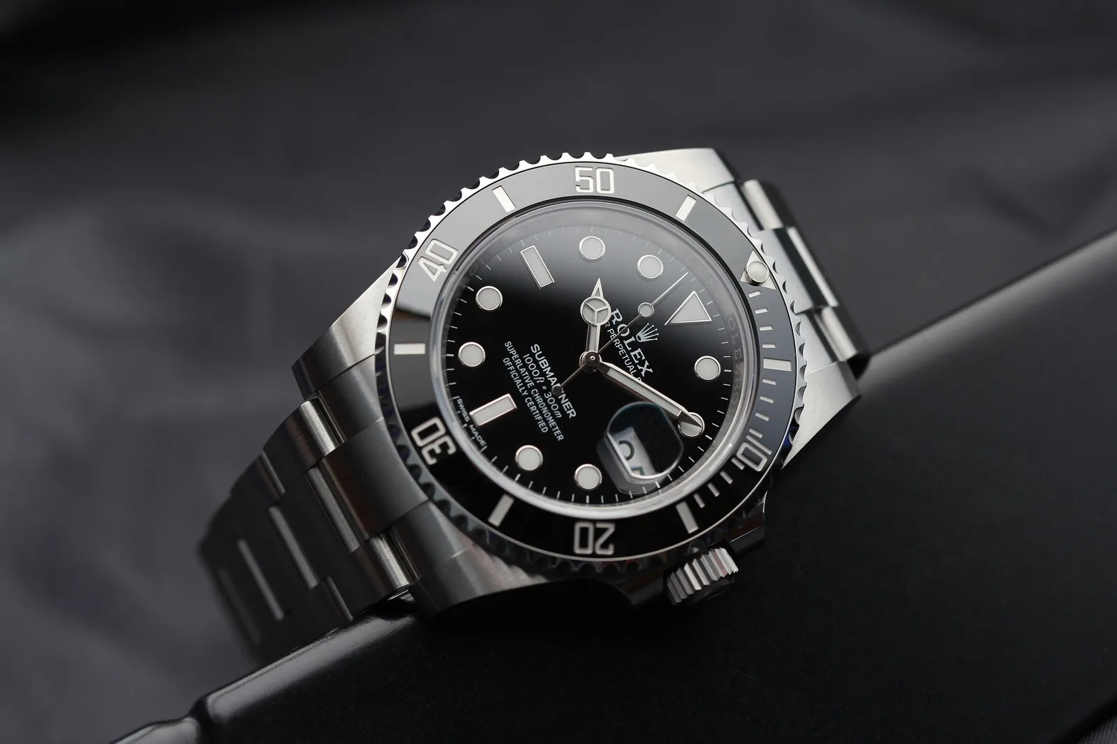 A stainless steel Rolex Submariner photographed on dark fabric