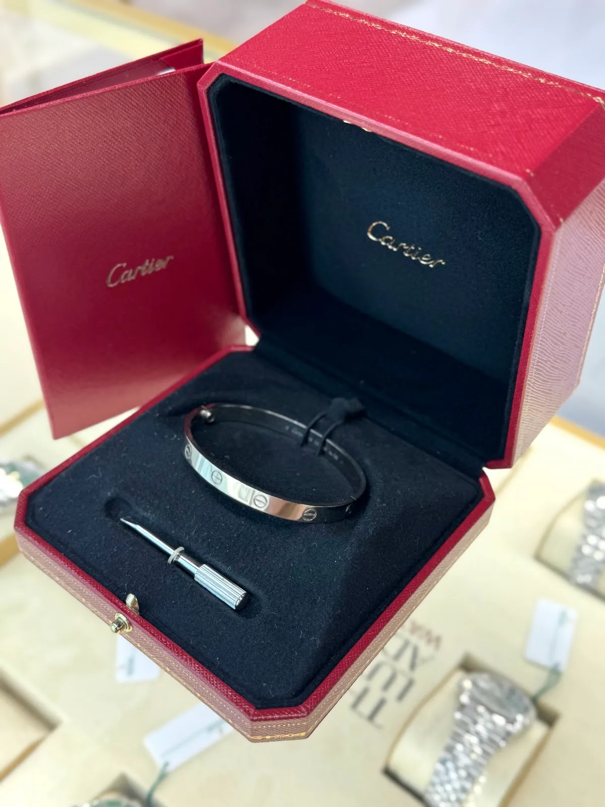 A Cartier Love bracelet presented in its red box