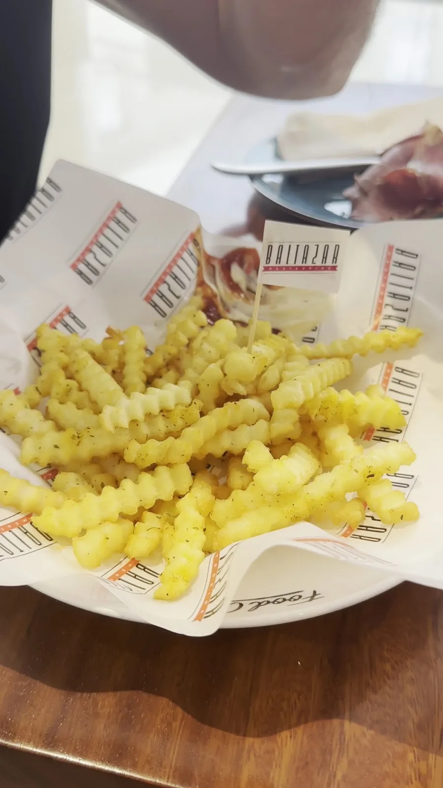 Crinkle-cut fries served in branded paper