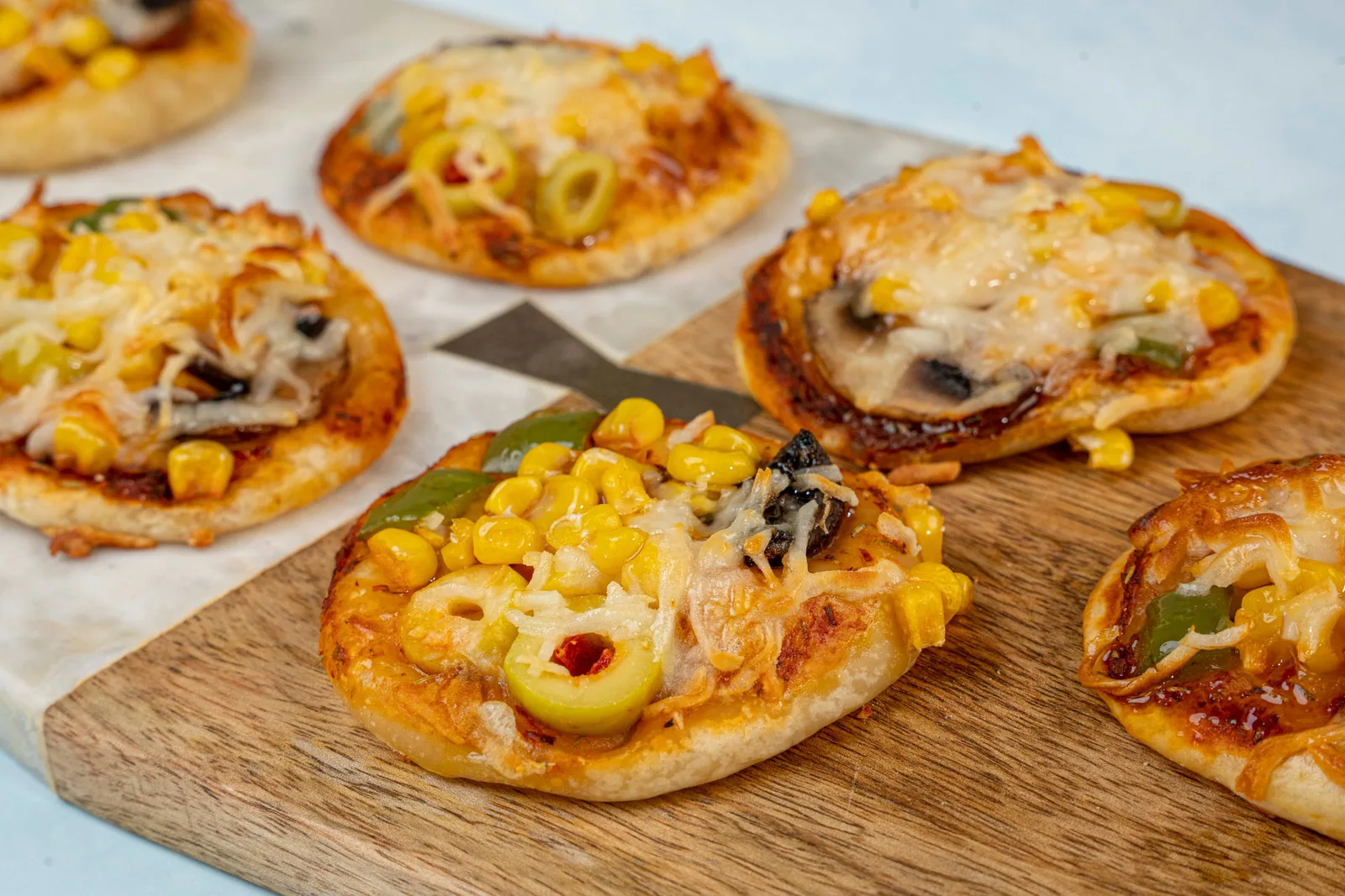 Mini pizzas with corn, olives and peppers