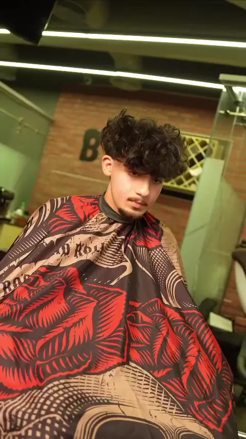 Client in a patterned cape after a curly haircut