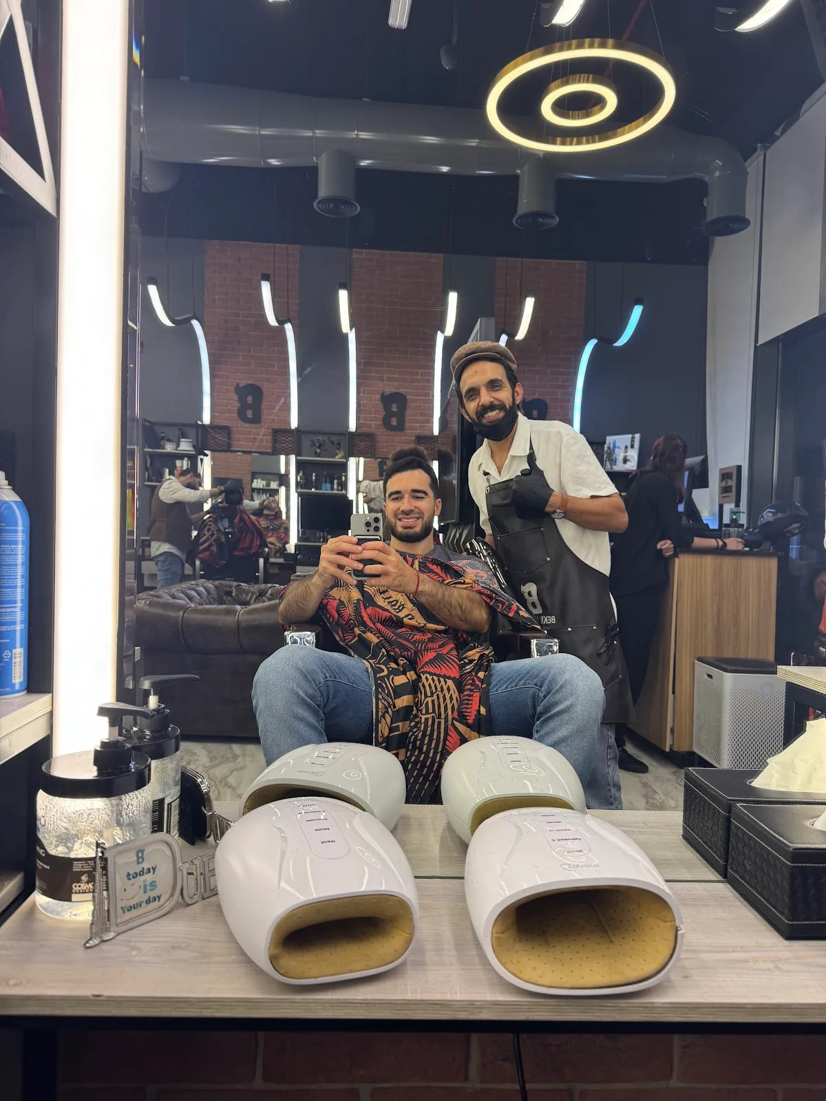 Client and barber photographed in the styling mirror