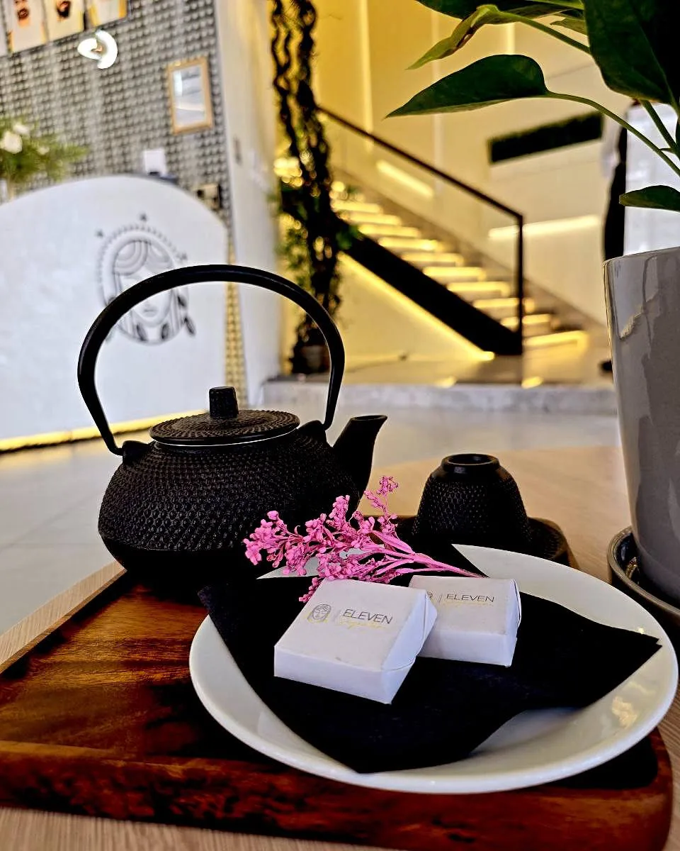 Cast-iron teapot and branded soaps on a wooden tray