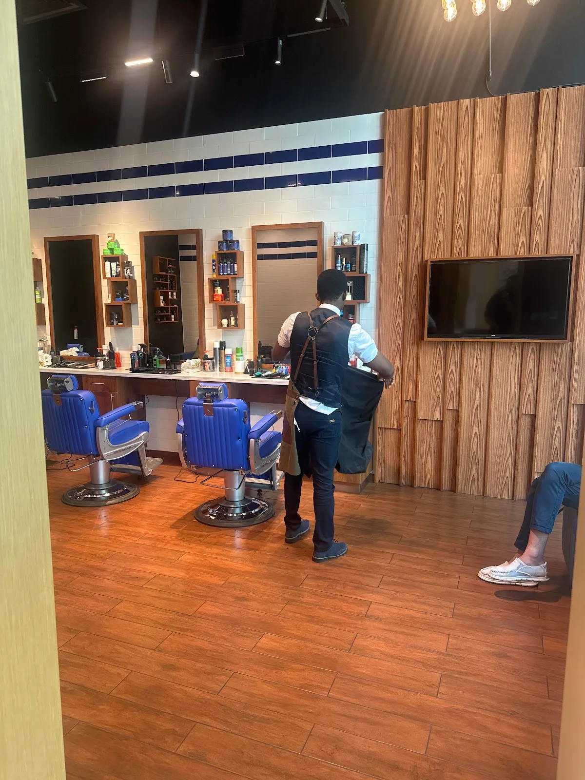 Royal-blue barber chairs and mirror stations at MK Barbershop