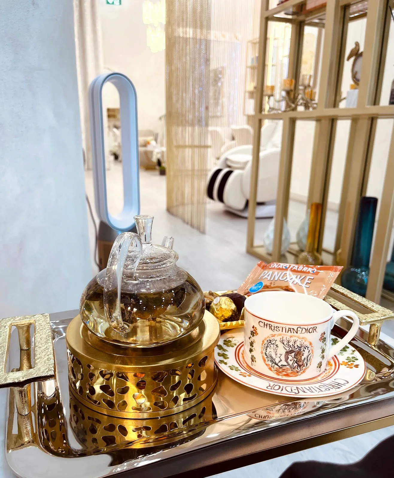 Glass teapot and cup served on a silver tray