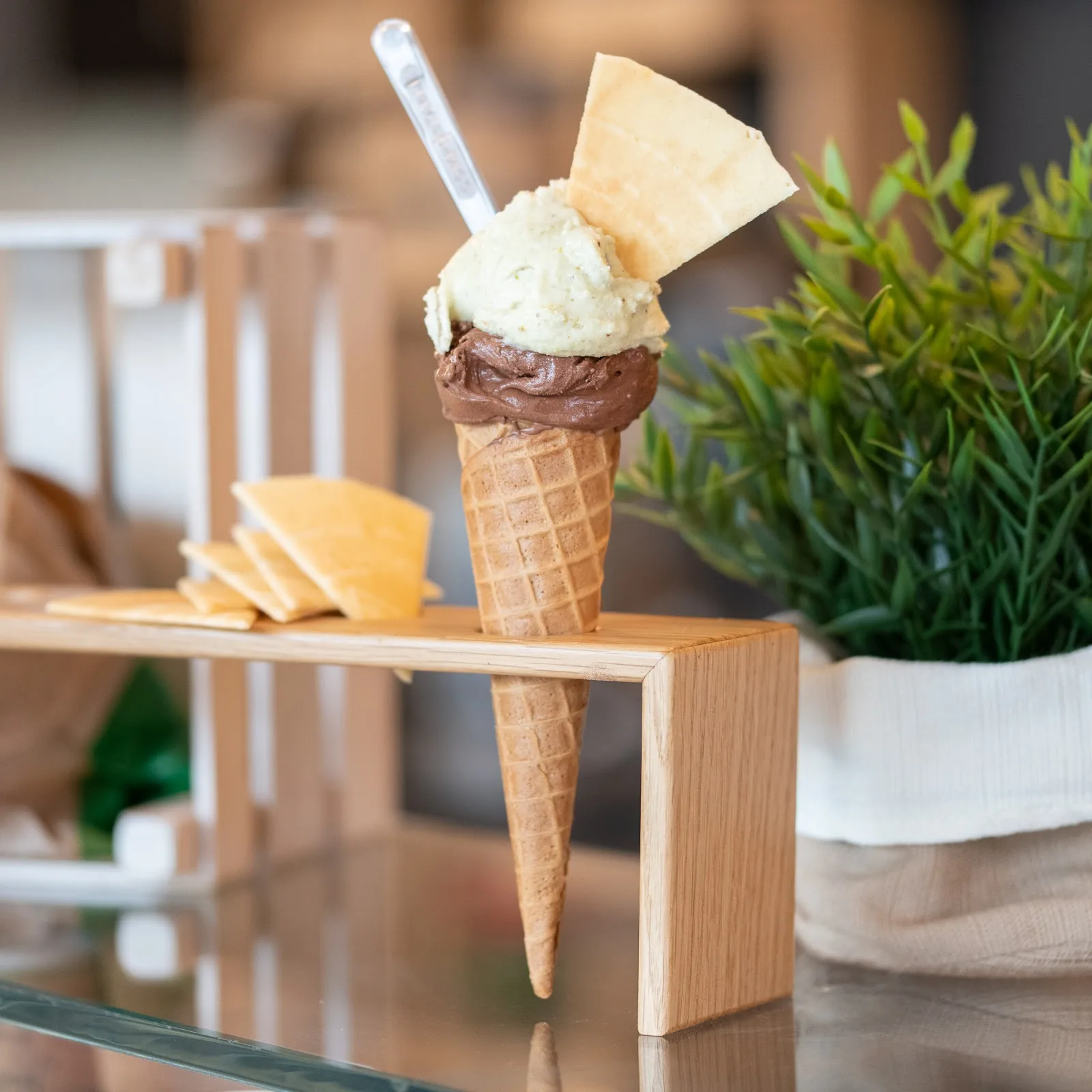 A waffle cone with chocolate and pistachio gelato topped with a crisp wafer at Cremeria Opera