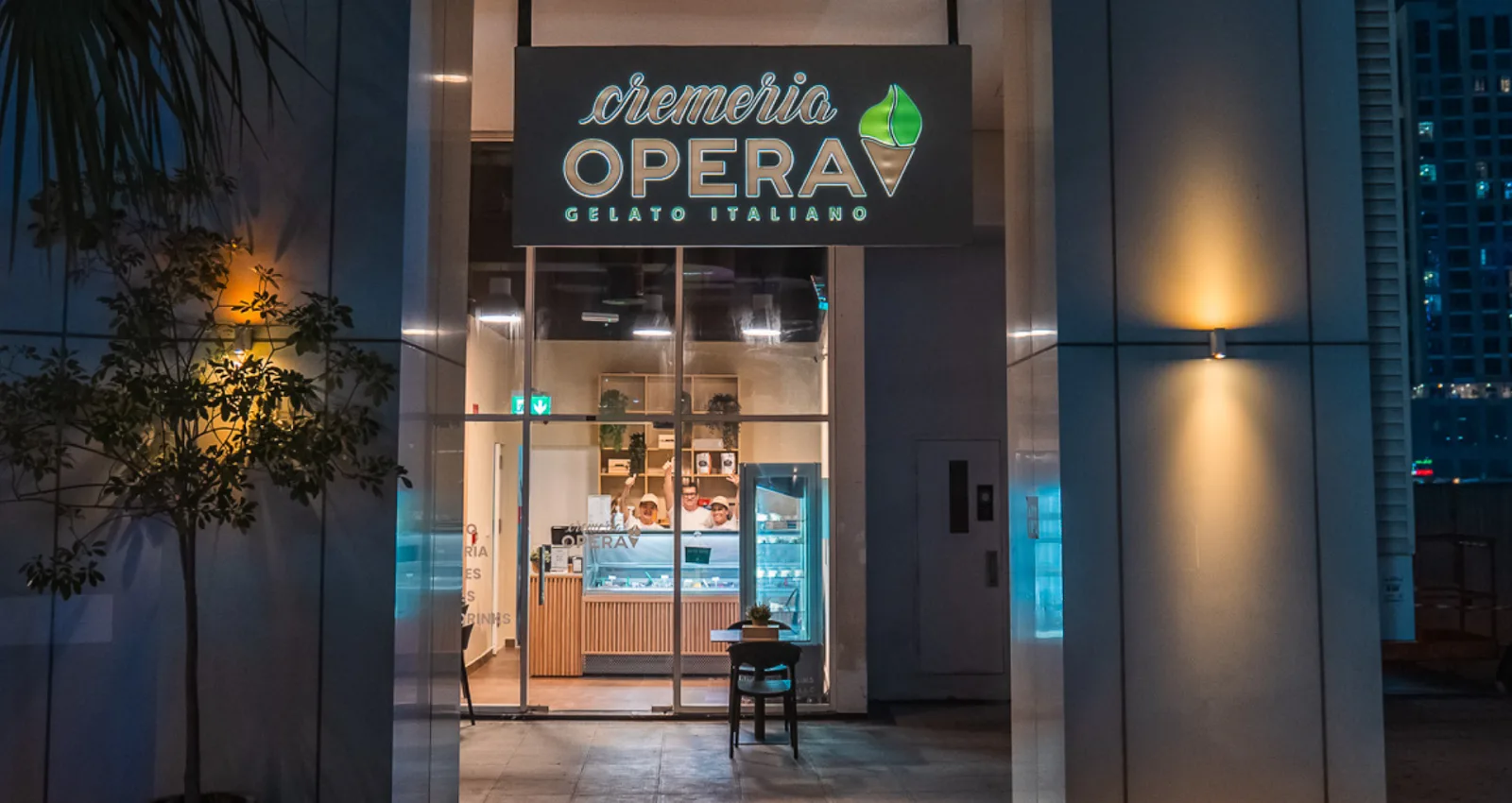 The lit Cremeria Opera storefront at night