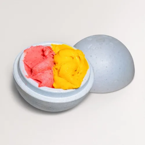 A fruit tartufo sphere cut open to show strawberry and mango