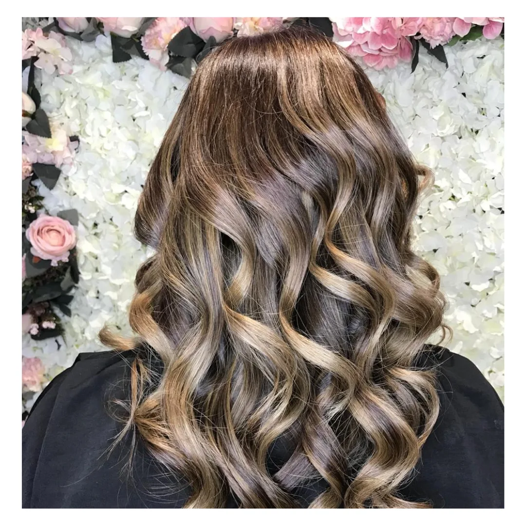 Balayage curls styled against a floral wall