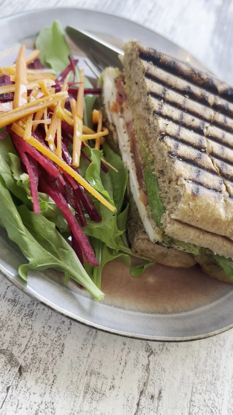 Grilled panini with a colourful salad on a plate