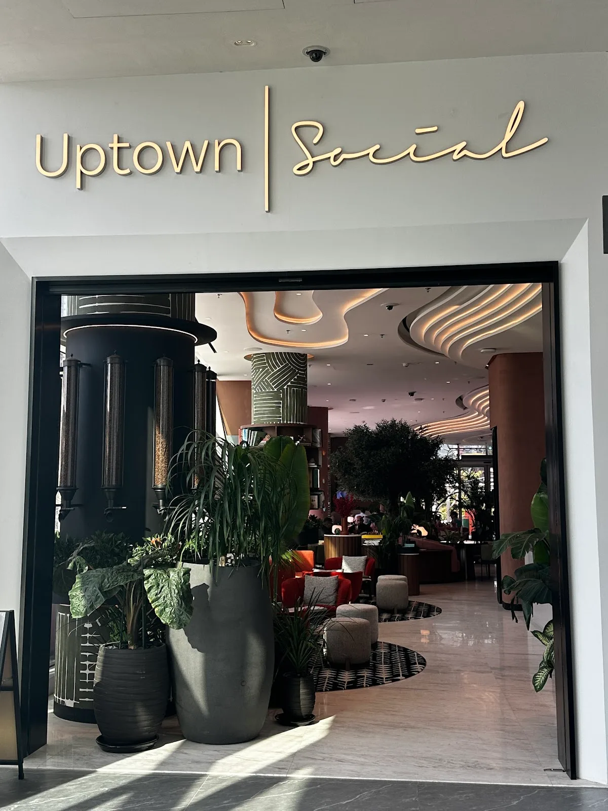 The Uptown Social entrance and gold script signage