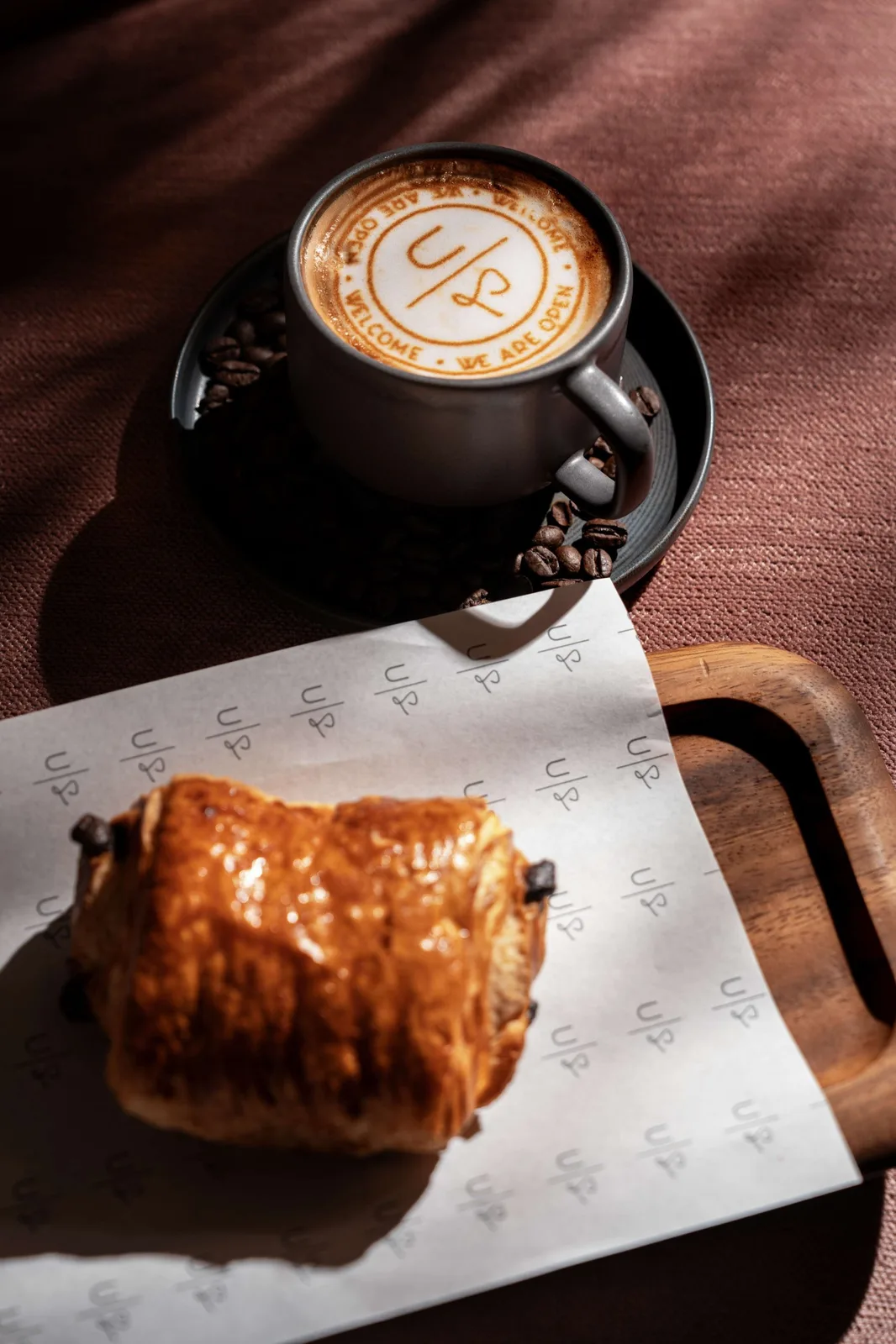Uptown Social branded latte art with a pain au chocolat