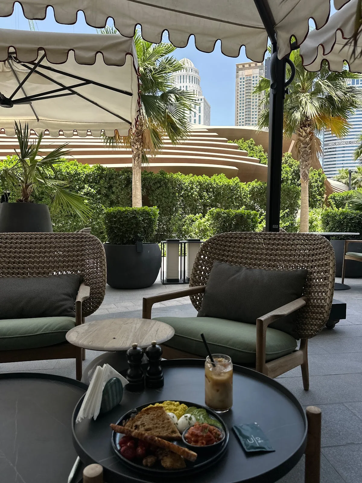 Woven lounge chairs on the terrace with JLT skyline beyond