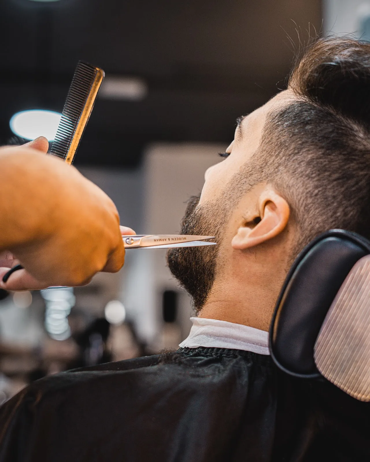 Close beard trim being shaped with scissors and comb