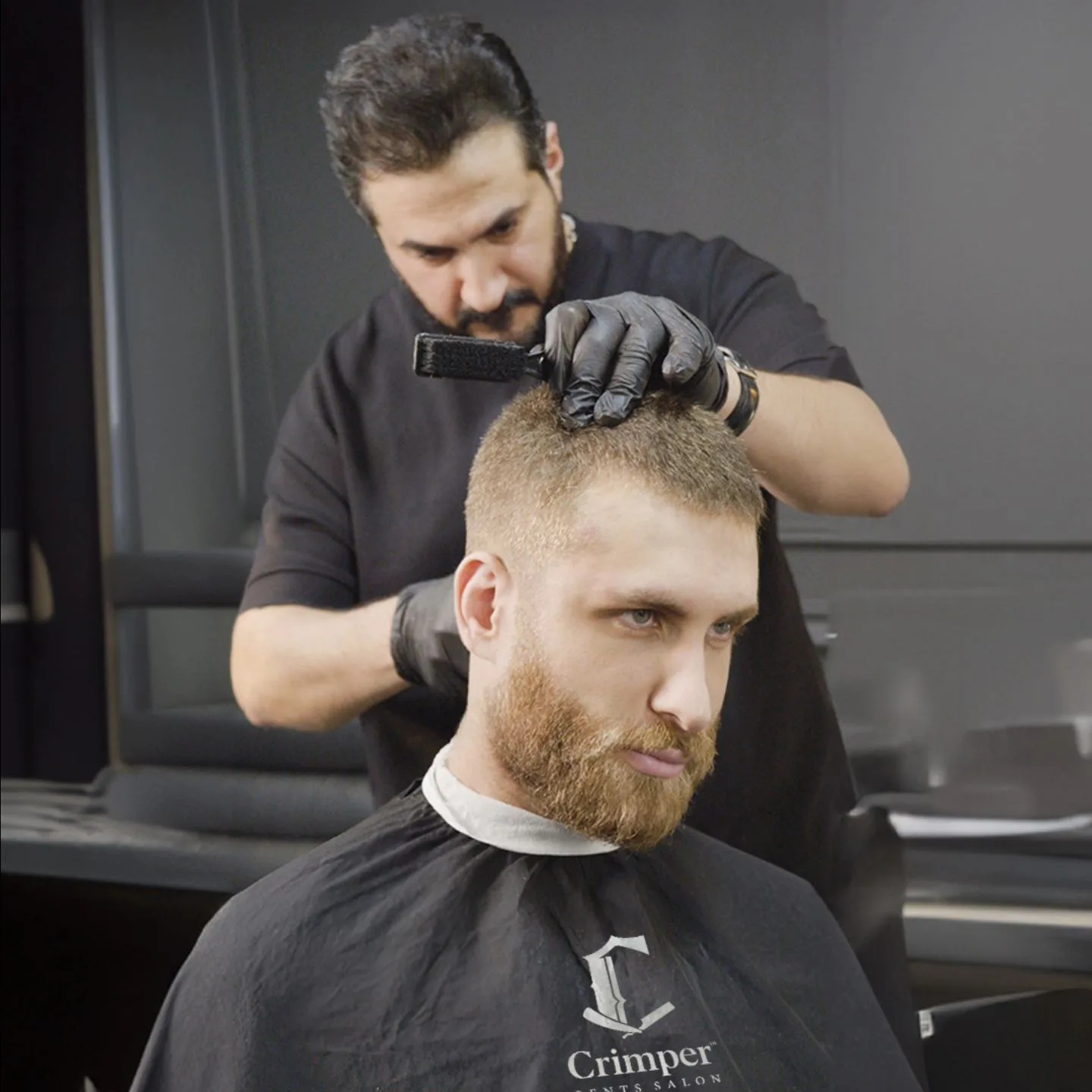 Barber brushing down a client's freshly cut hair