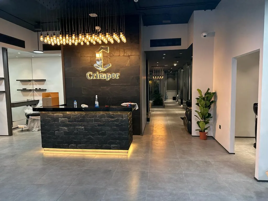 Crimper reception lobby with stone walls and Edison-bulb chandelier