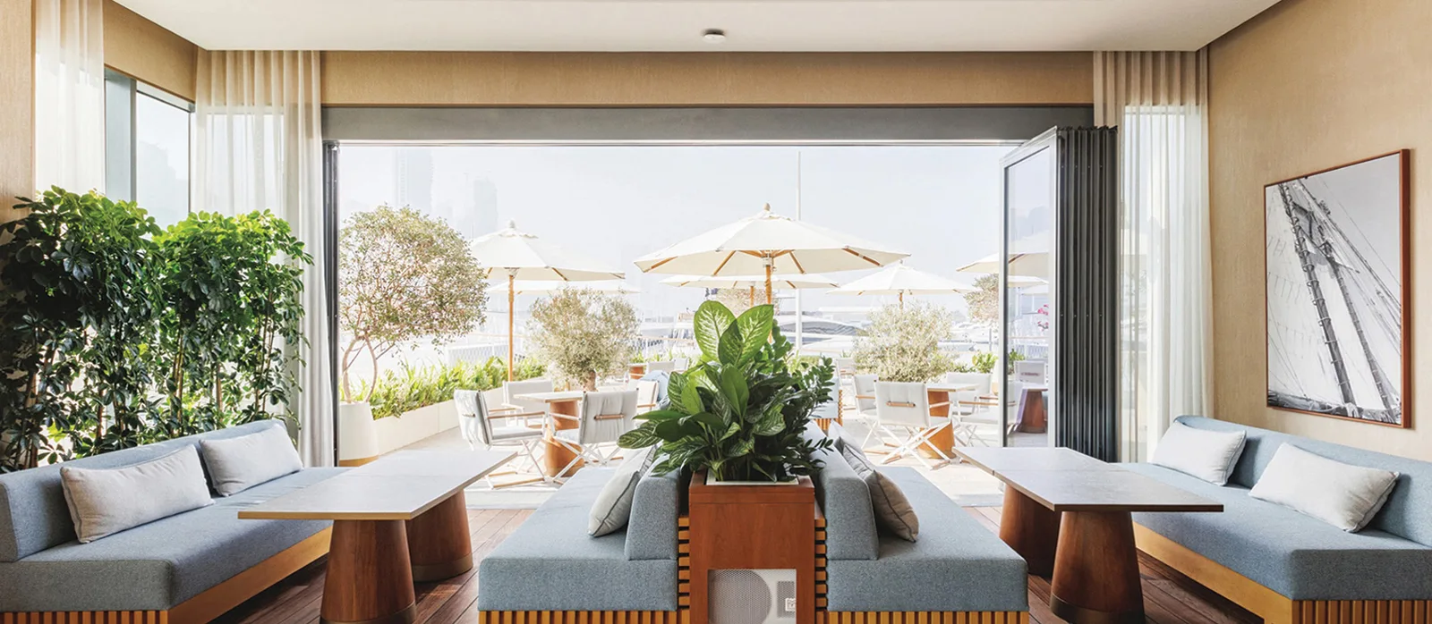 The Delizie lounge with soft blue seating opening onto the marina terrace