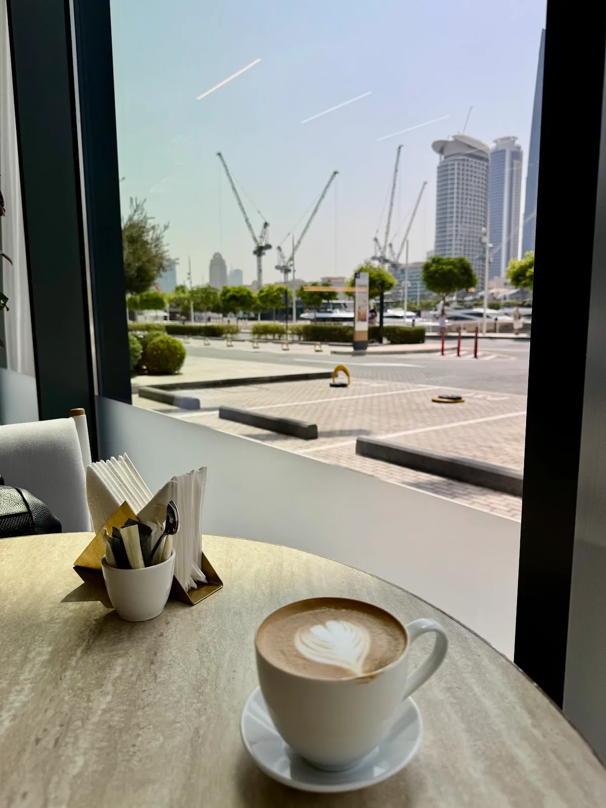 A latte by the window with the marina and skyline beyond