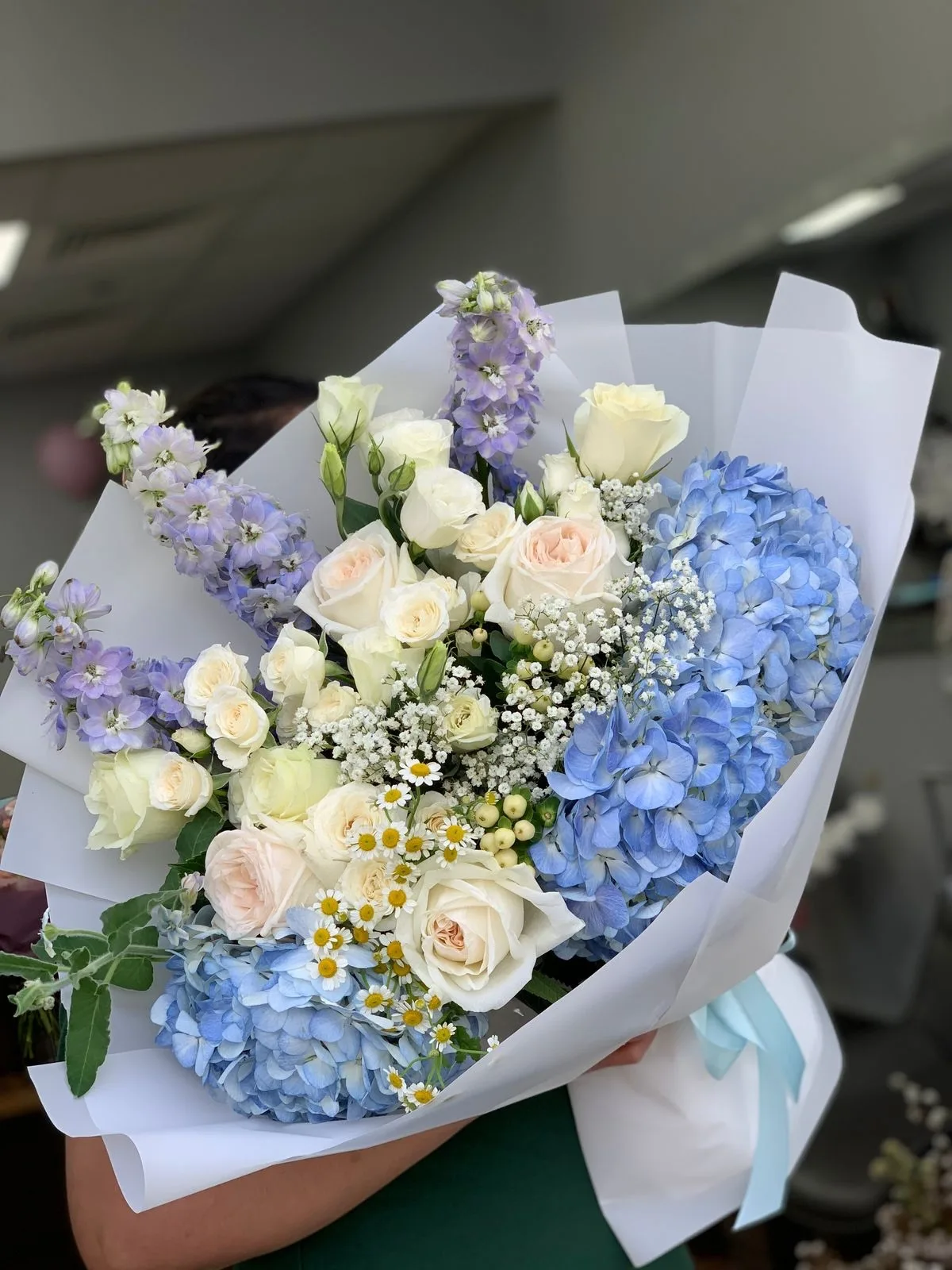 Bouquet of blue hydrangea, white roses, delphinium and chamomile
