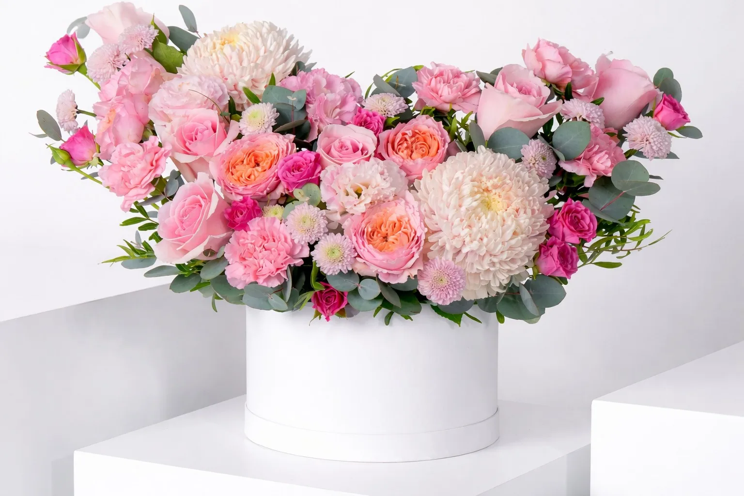 Pastel pink hatbox arrangement with roses, chrysanthemums and eucalyptus