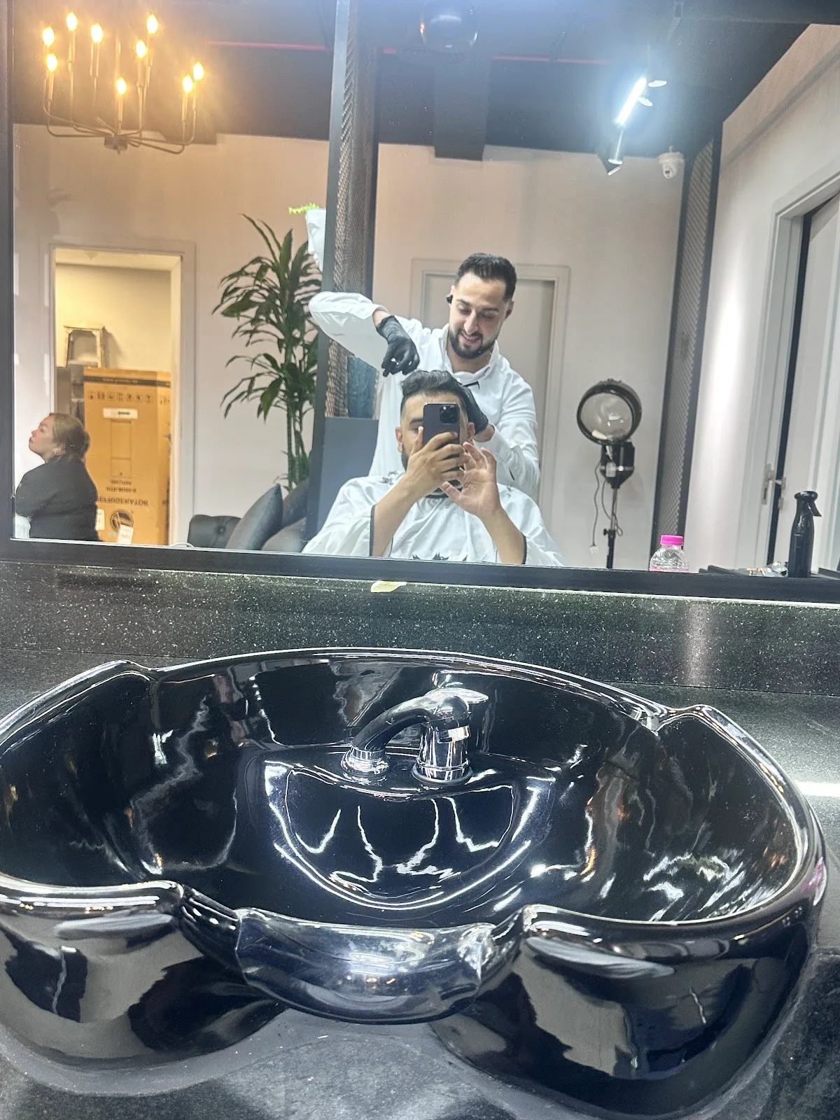 Barber at work at the styling mirror inside The Syndicate