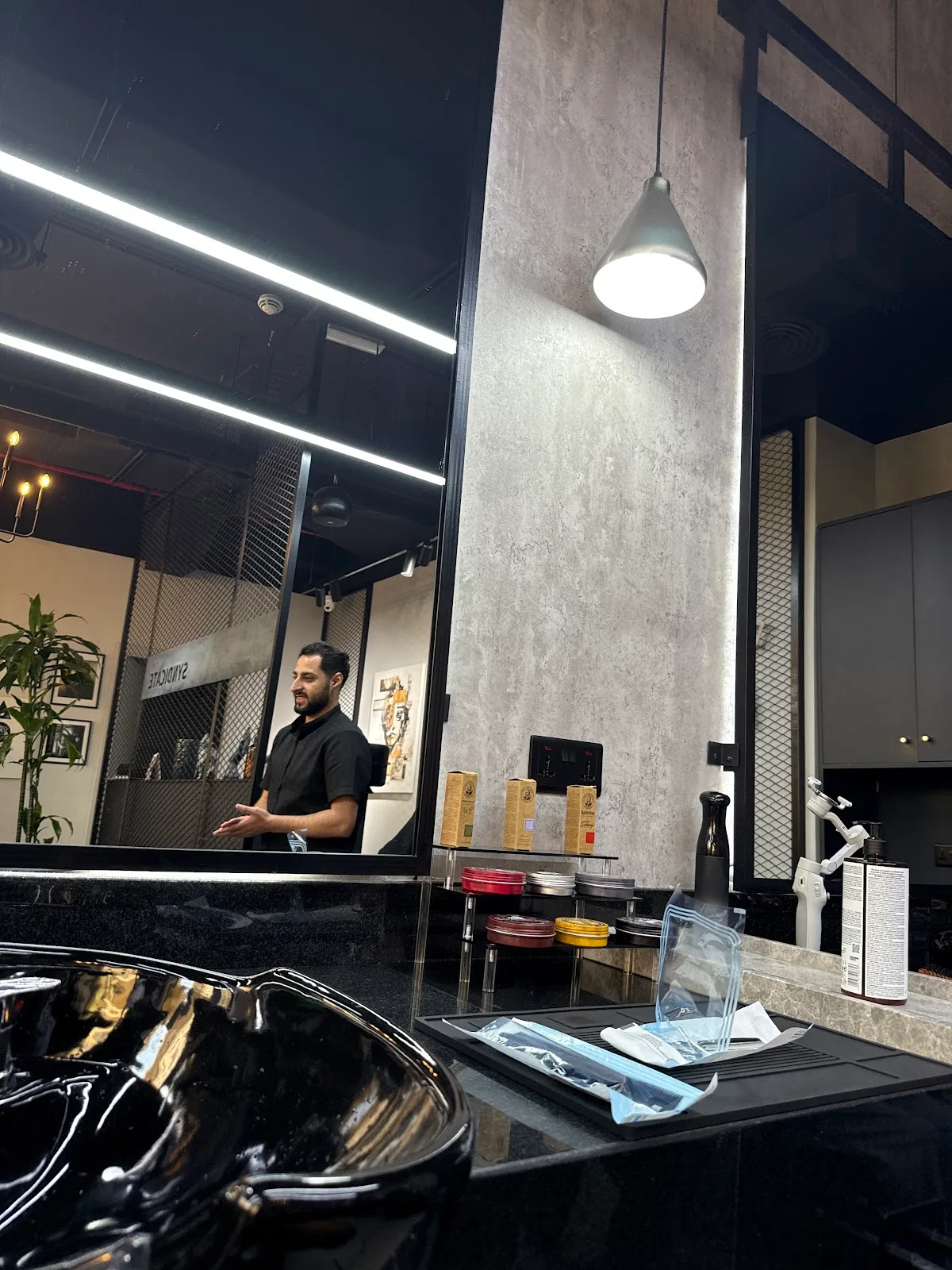 The Syndicate interior — black wash basin under a pendant light