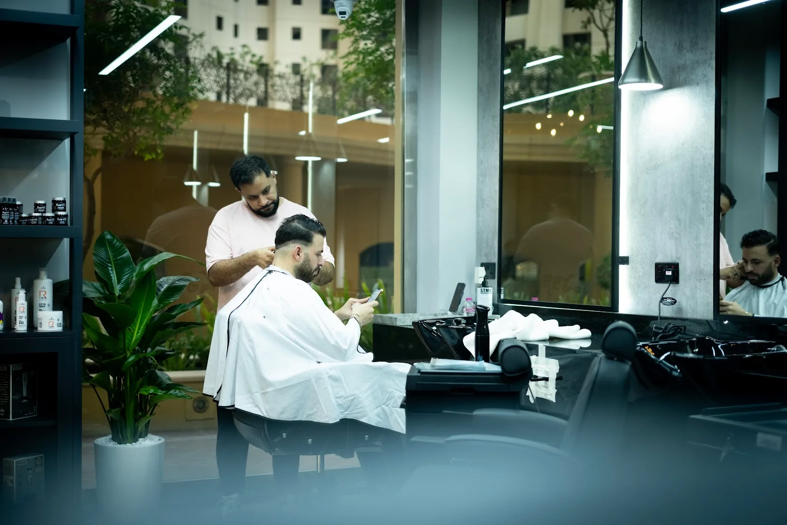 Wide view of The Syndicate salon floor with styling stations and greenery