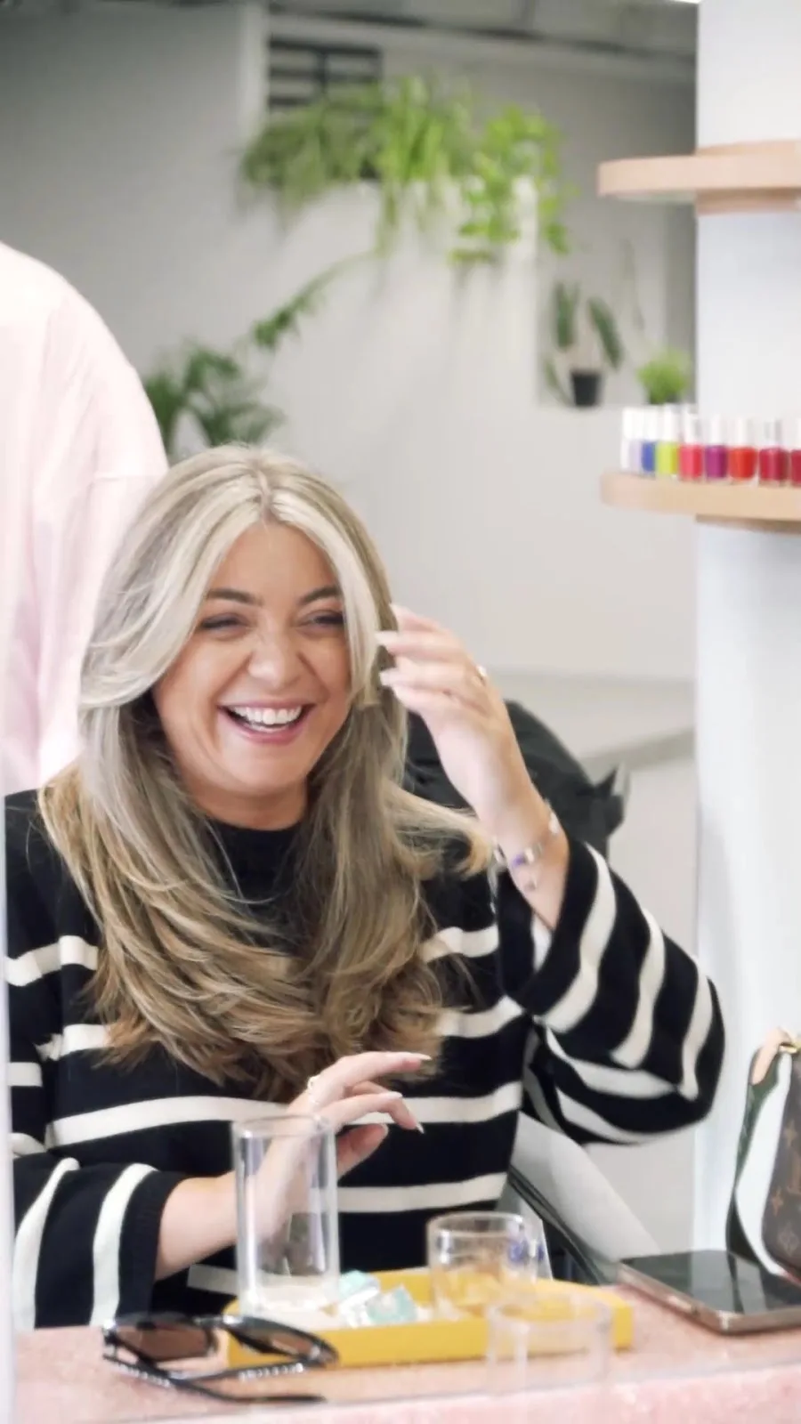 A client laughing in the studio after a blow-dry