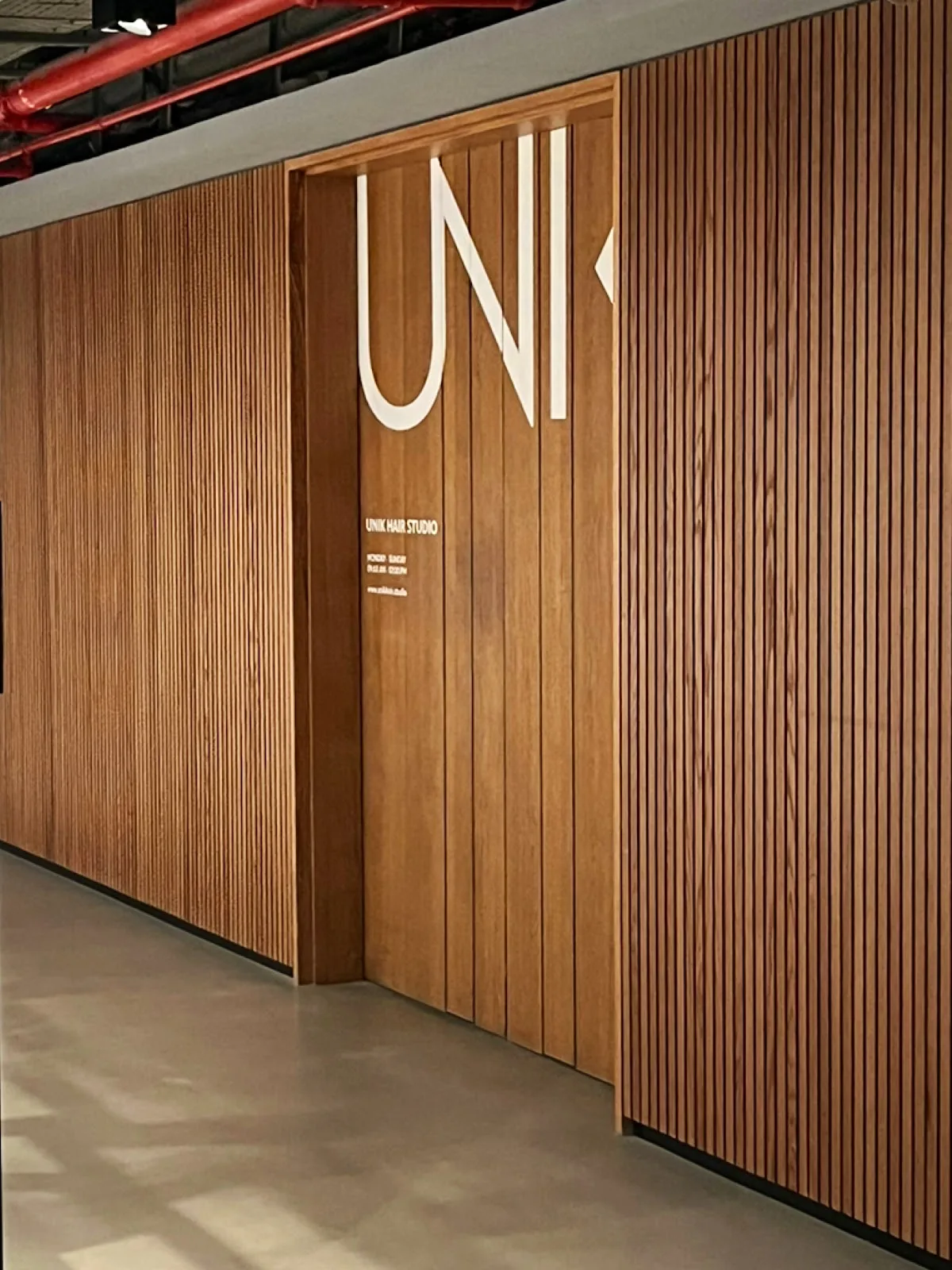 UNIK signage on the studio's timber-clad entrance wall