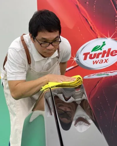 Technician buffing a panel with a microfibre cloth