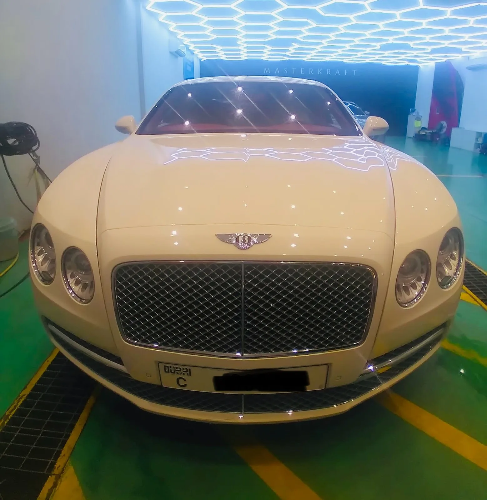 White luxury saloon under the studio's hexagon lighting