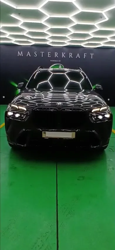 Black SUV detailed under the studio lighting