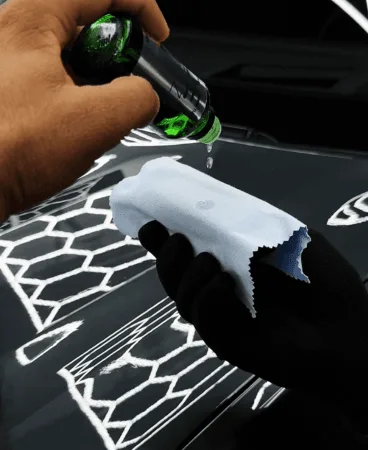 Ceramic coating applied to a black bonnet with hexagon light reflections
