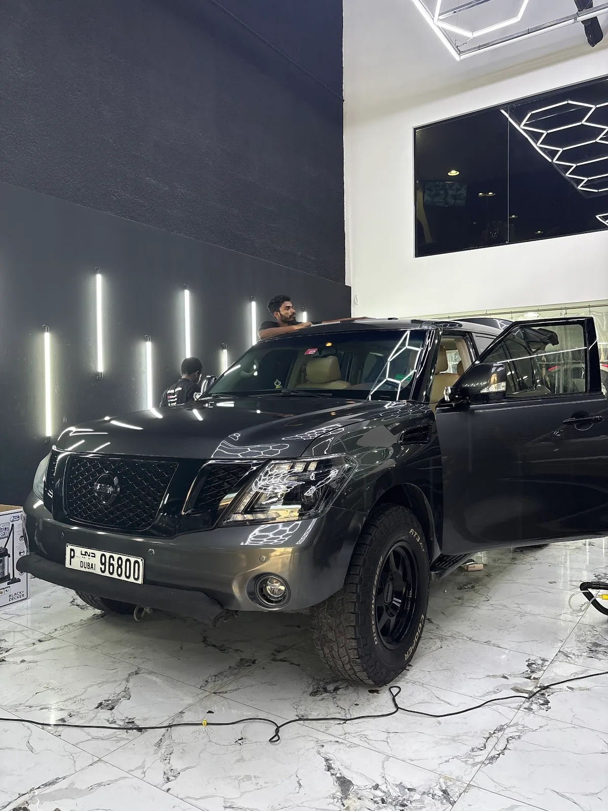 Nissan Patrol being detailed with hexagon light reflections across the paint
