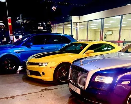 Camaro, Rolls-Royce and other performance cars parked together inside the garage