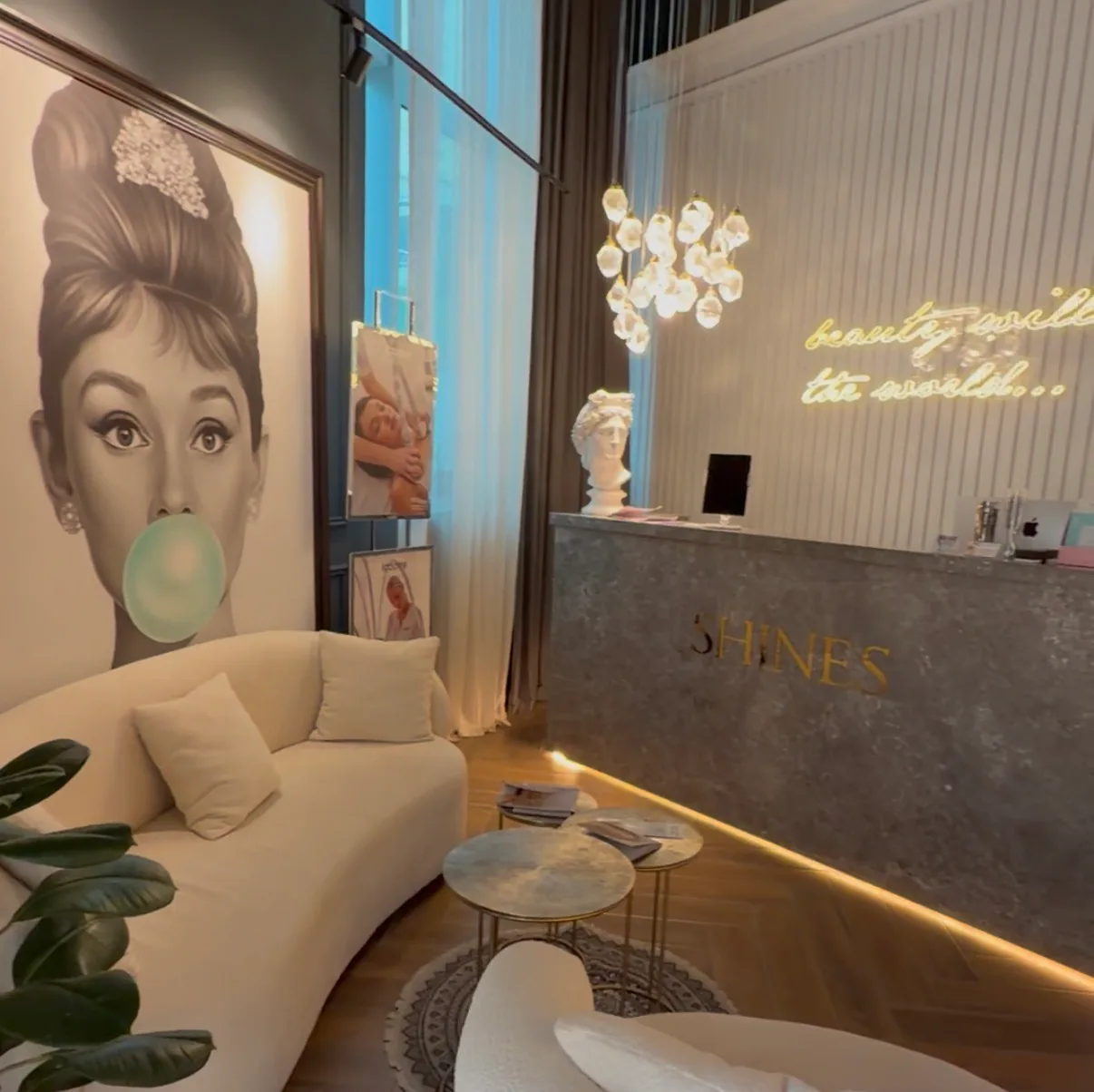 Shines reception lounge with crystal lighting, a sculptural bust and the gold SHINES desk