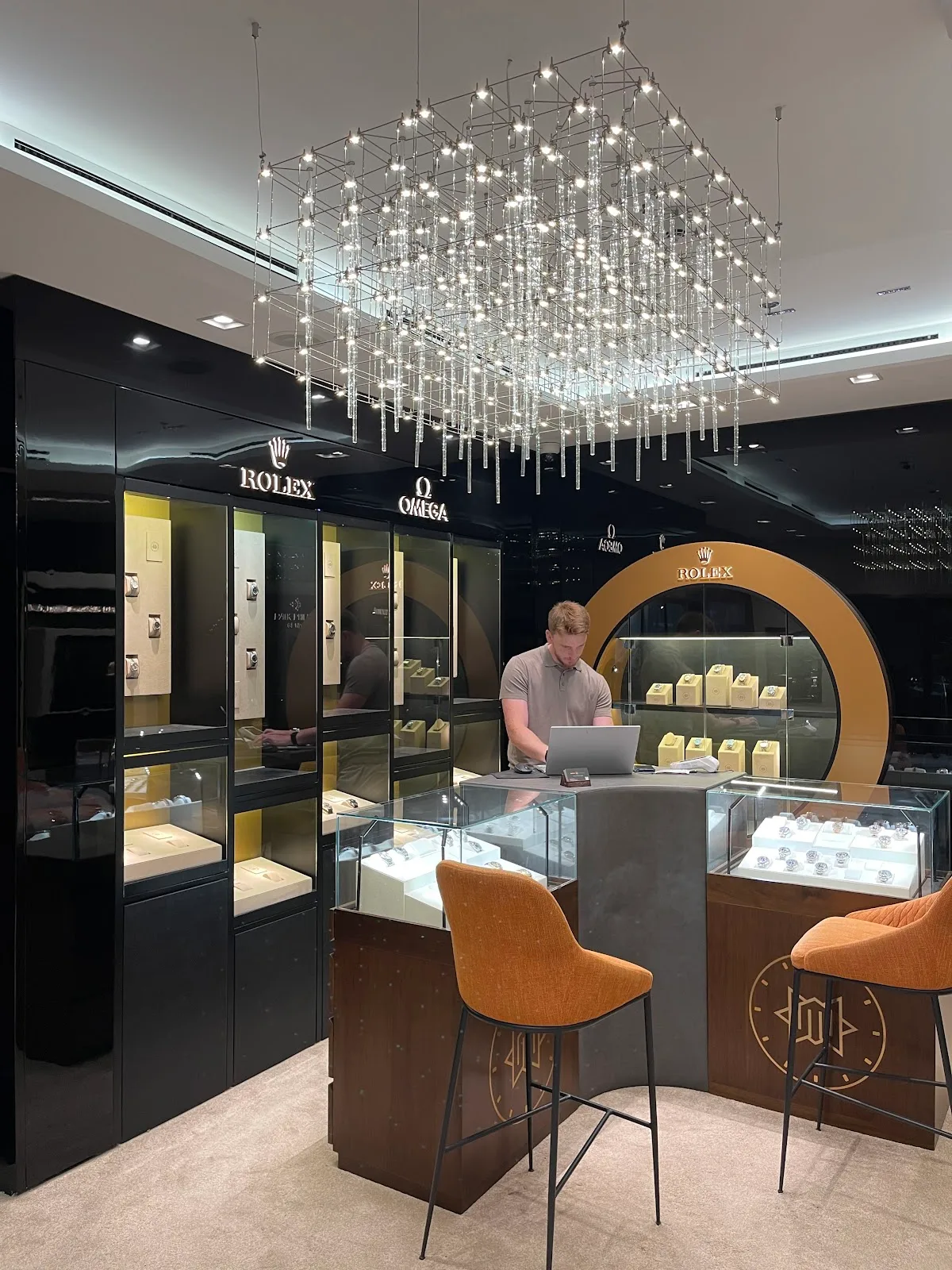 WatchMaestro interior with lit display cabinets and a specialist at the counter