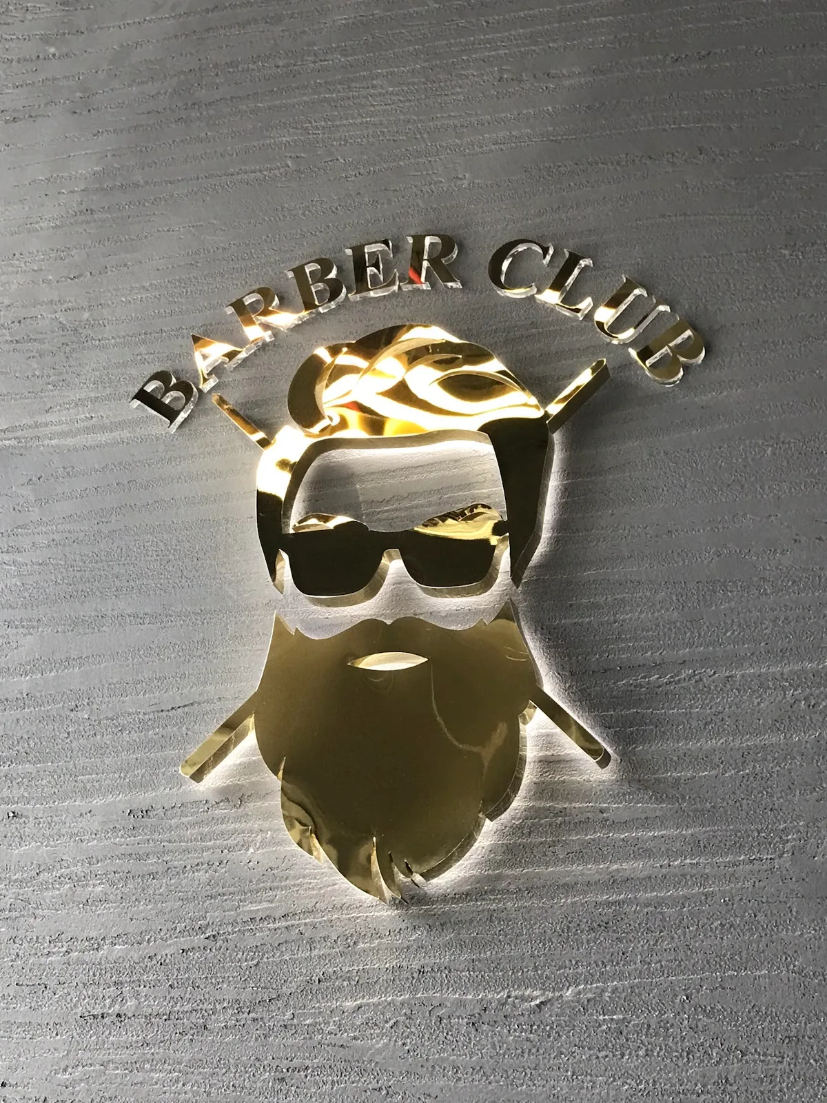 Gold Barber Club emblem on the wall