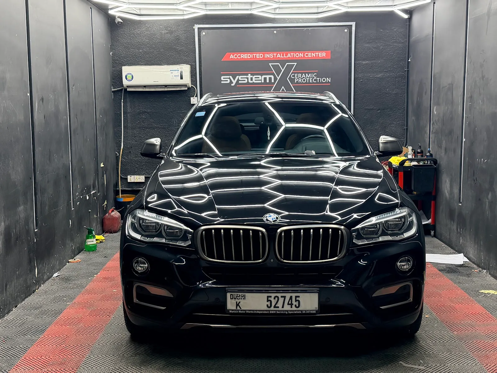 A black BMW SUV reflecting the bay lighting