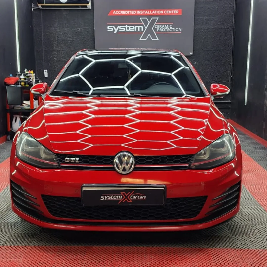 A red hatchback with a mirror-gloss finish