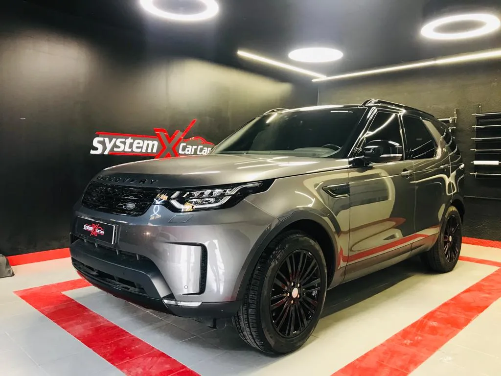 A grey Land Rover Discovery on the red display floor